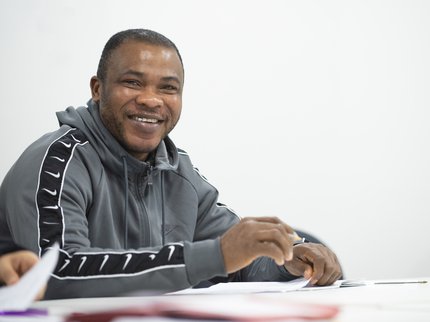 A smiling man holding a pen