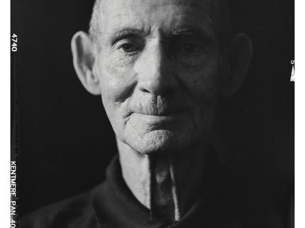 A black and white image of an older man in a black shirt