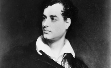 Black and white picture of Byron in a white shirt and black smock