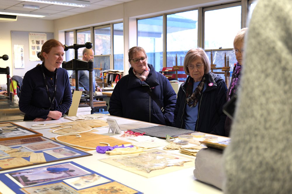 Group stood around a table displaying historical documents