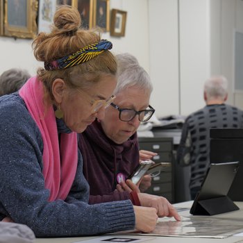 Two people viewing augmented reality version of historic map via smartphone