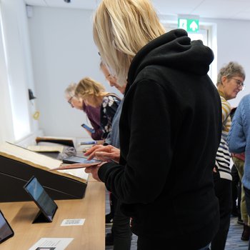 Line of visitors viewing augmented reality content via their smartphones