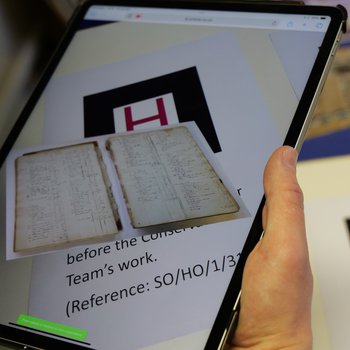 Image of ledger book prior to conservation treatment viewed via tablet device