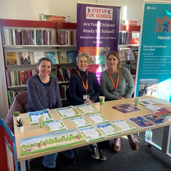 Three people sat behind a stall with leaflets