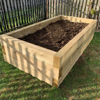 Raised planter filled with compost