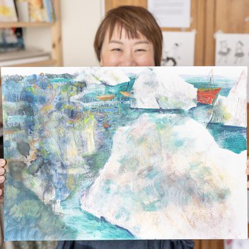 Photo of artist holding up a pastel drawing.