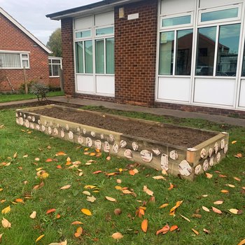 Raised flower bed with wooden shapes around the edge