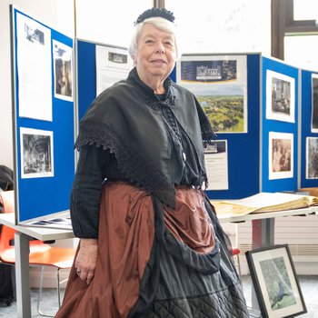 A woman dressed up as a Victorian house keeper.