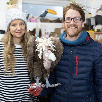 Photo of man and woman holding a small vulture sculpture