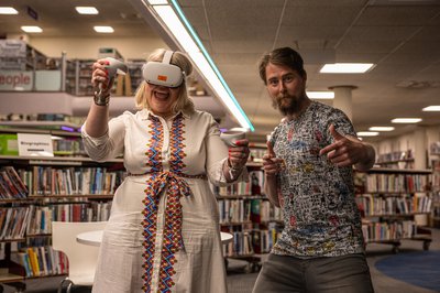 Two adults wearing VR headsets in the library