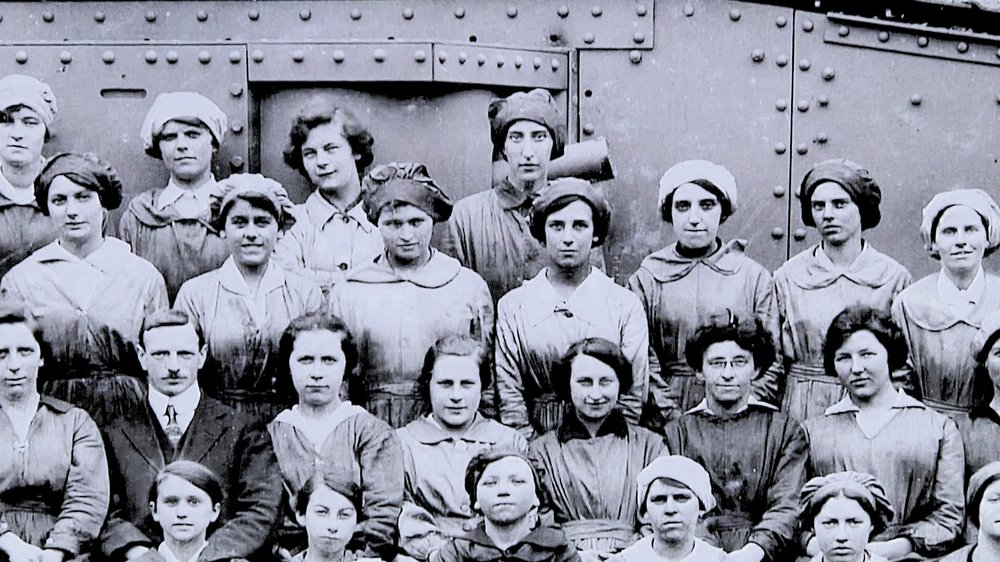 Munitionettes standing in front of tank