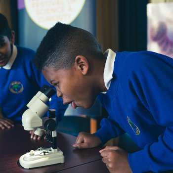 Two primary school pupils using a microscope.