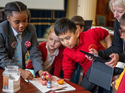 A group of children around a table doing a science experiment