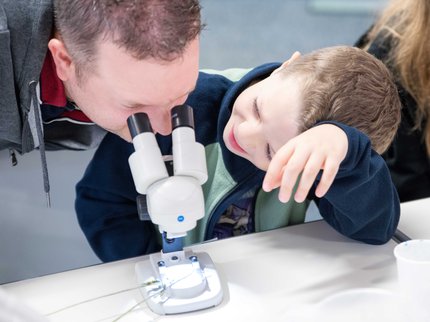 Parent and child looking into a microscope