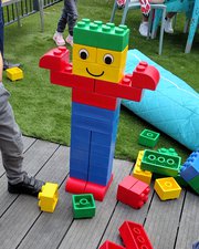 A sculpture in the shape of a person made from giant Lego blocks.