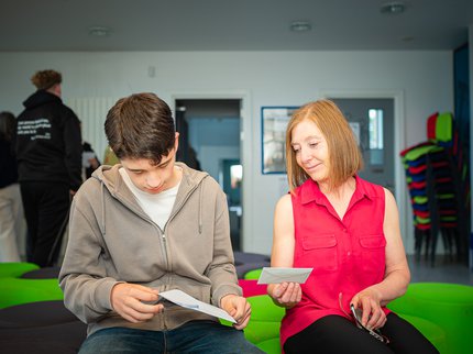 A young person ands their tutor looking at GCSE results.