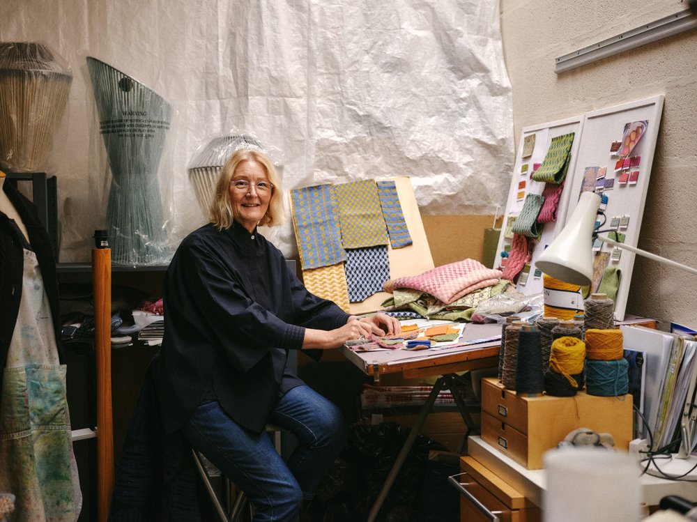 Designer Jane Withers sitting at her desk in her design studio