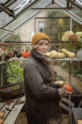 Image of author, Kathy Slack in a greenhouse.