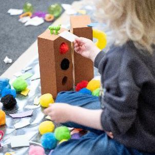 Child playing with pompoms and building bricks.