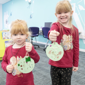 Children holding their decorated baubles at Christmas market