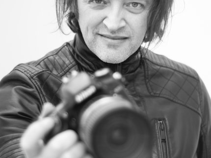 Black and white photography of man holding camera