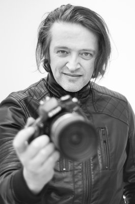 Black and white photography of man holding camera