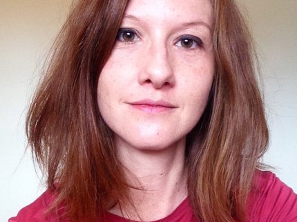 Photo of author Philippa East - a white woman with dark brown hair, wearing a dark red top.