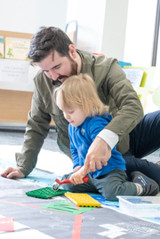 Parent and child playing with lego in the library