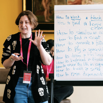 Leanne stood next to a white board gesturing to an audience