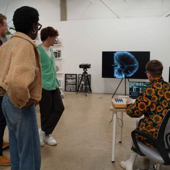 Young people gathered around a computer screen