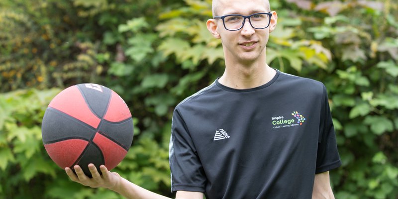 A young person holding a basketball.