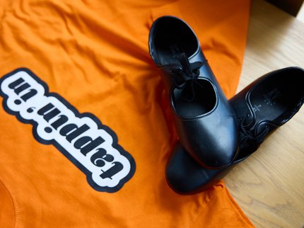 Tap dance shoes against an orange background.