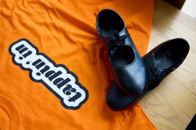 Tap dance shoes against an orange background.