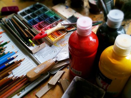 A variety of art materials, paints, coloured pencils and paint pallette
