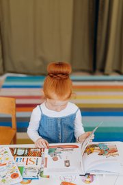 girl opening and reading a picture book