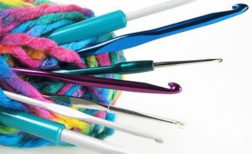 Several coloured crochet hooks held together with strands of yarn