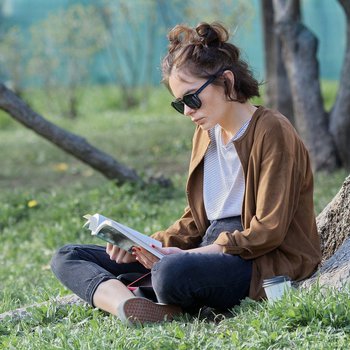 Girl sat in woodland reading