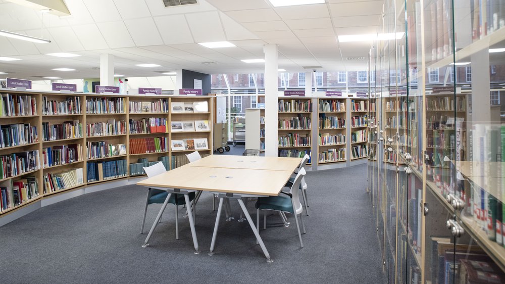 Library with bookcases around the edge and a table in the centre
