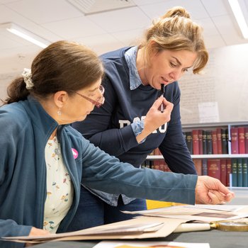 Two people look at historical documents