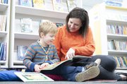 Parent and child reading together in the library