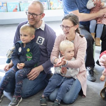 Man, woman and two small children watching a performance